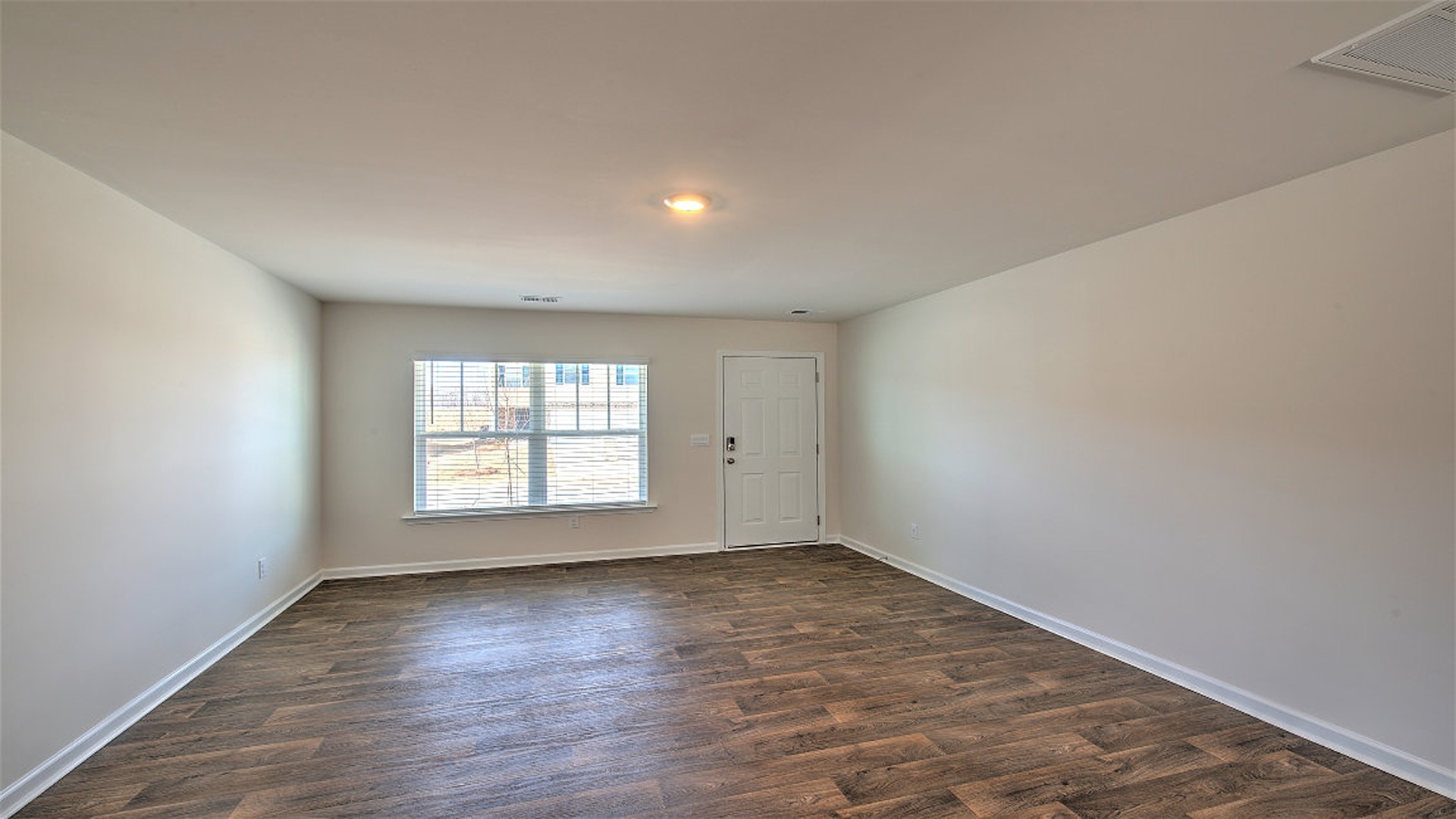 Spacious living area with vinyl flooring and a window for light
