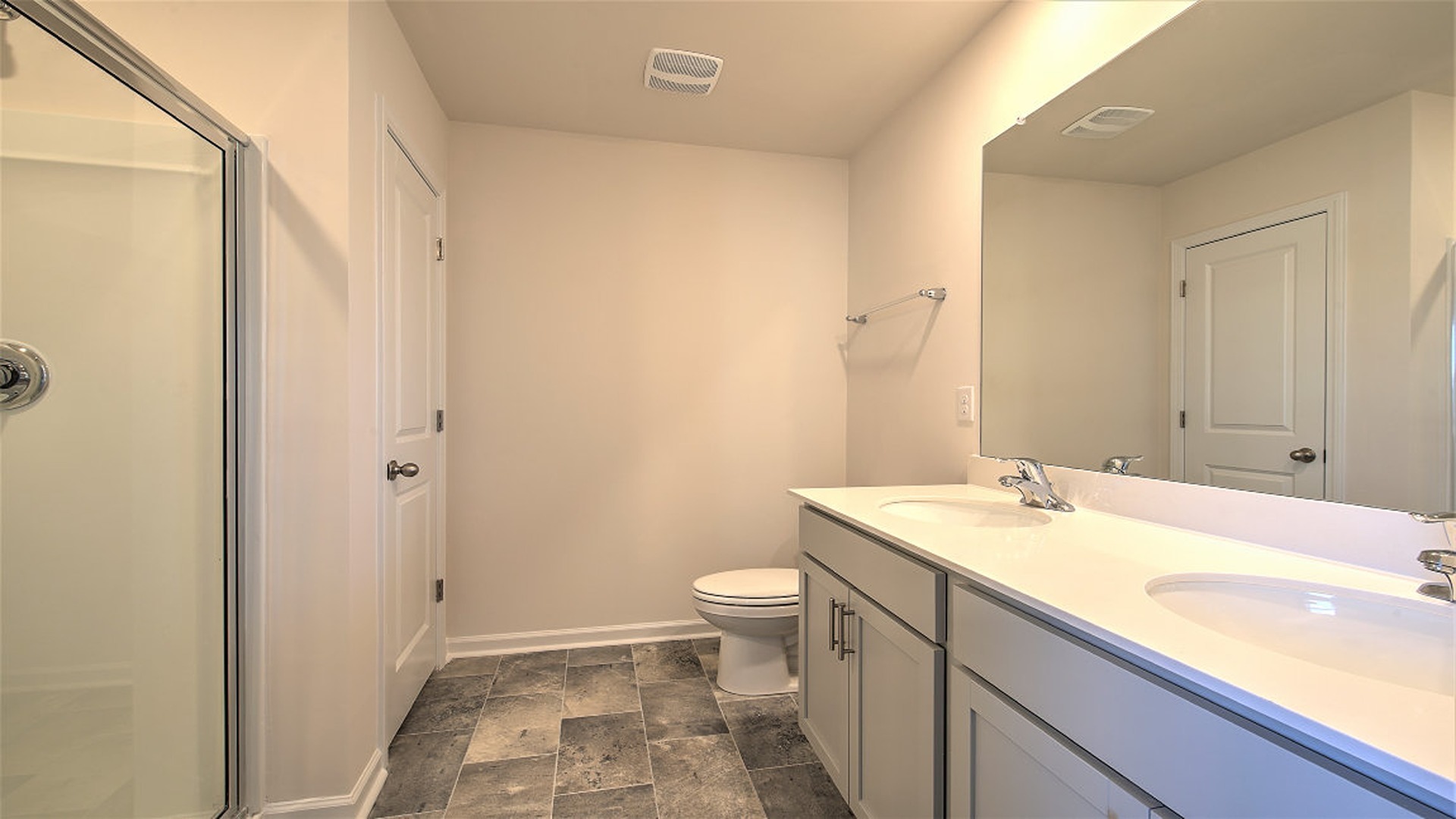 En-suite primary bathroom with double vanity and standup shower
