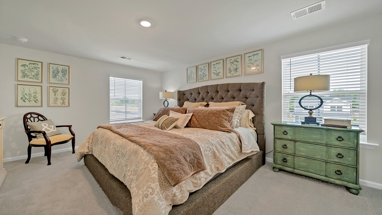 Aisle primary bedroom with several windows for light and carpet flooring