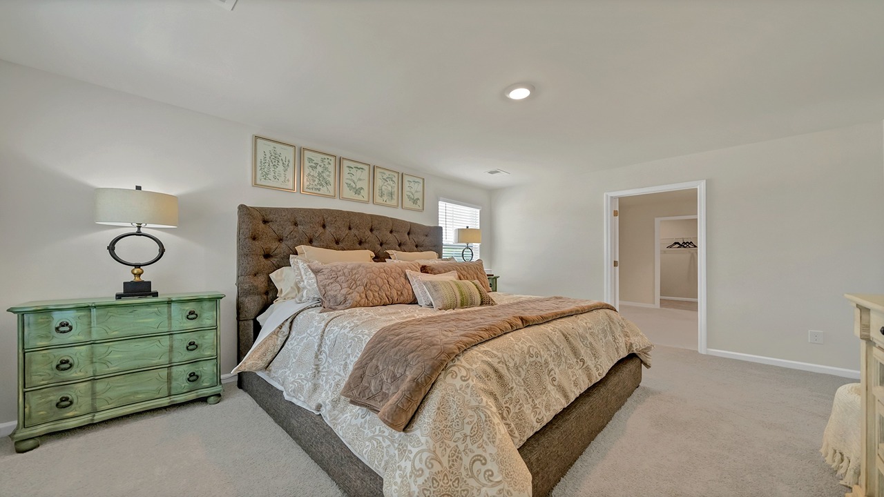 Aisle primary bedroom with several windows for light and carpet flooring
