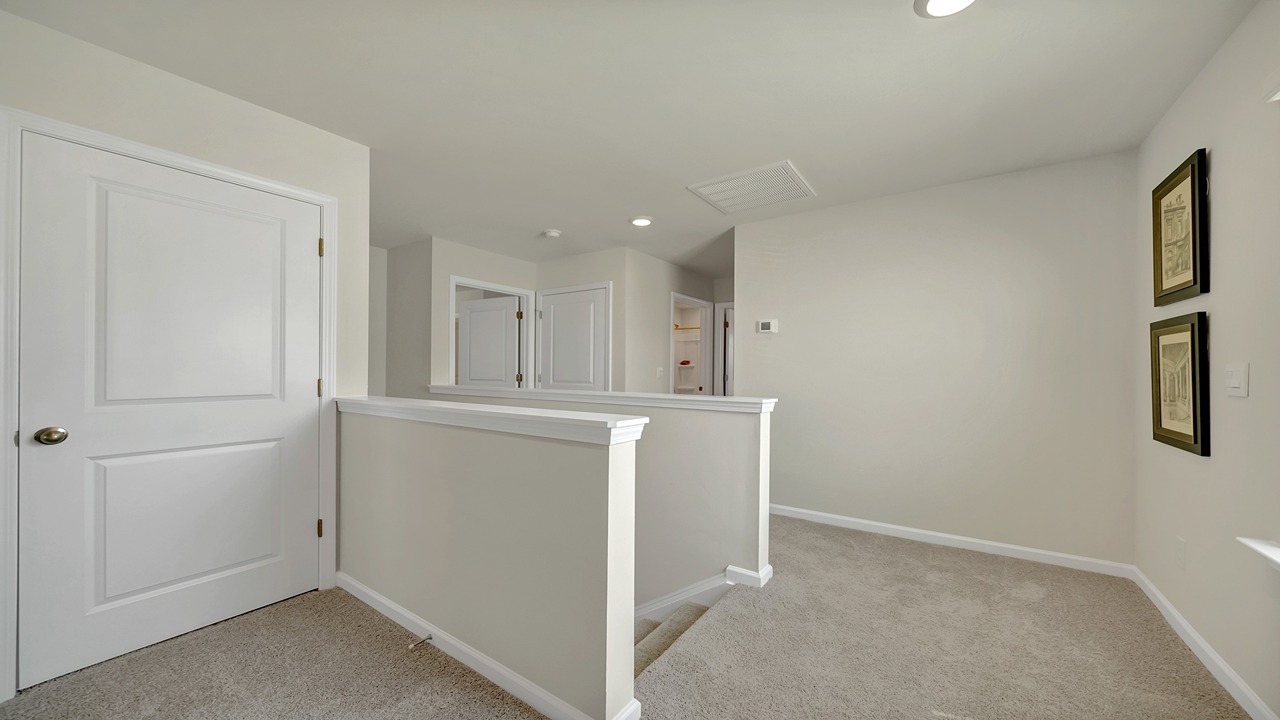 Upstairs landing with carpet flooring and natural light