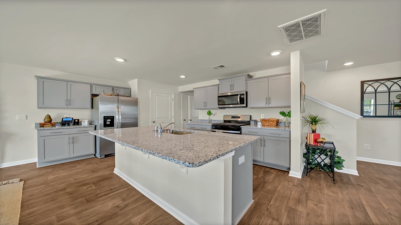 Aisle kitchen with granite countertops and gray cabinetry