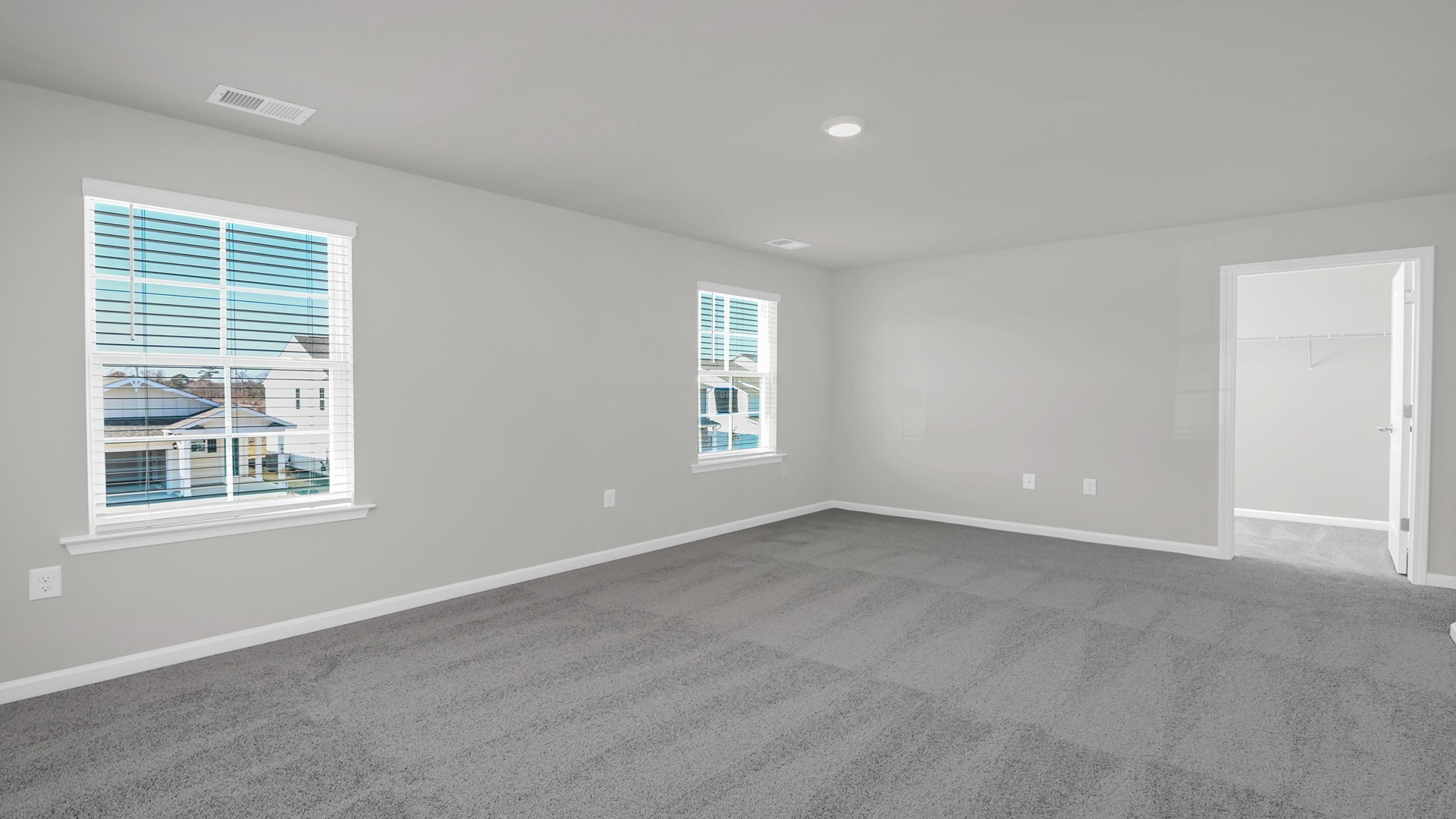 Primary bedroom upstairs with 2 windows and carpet flooring