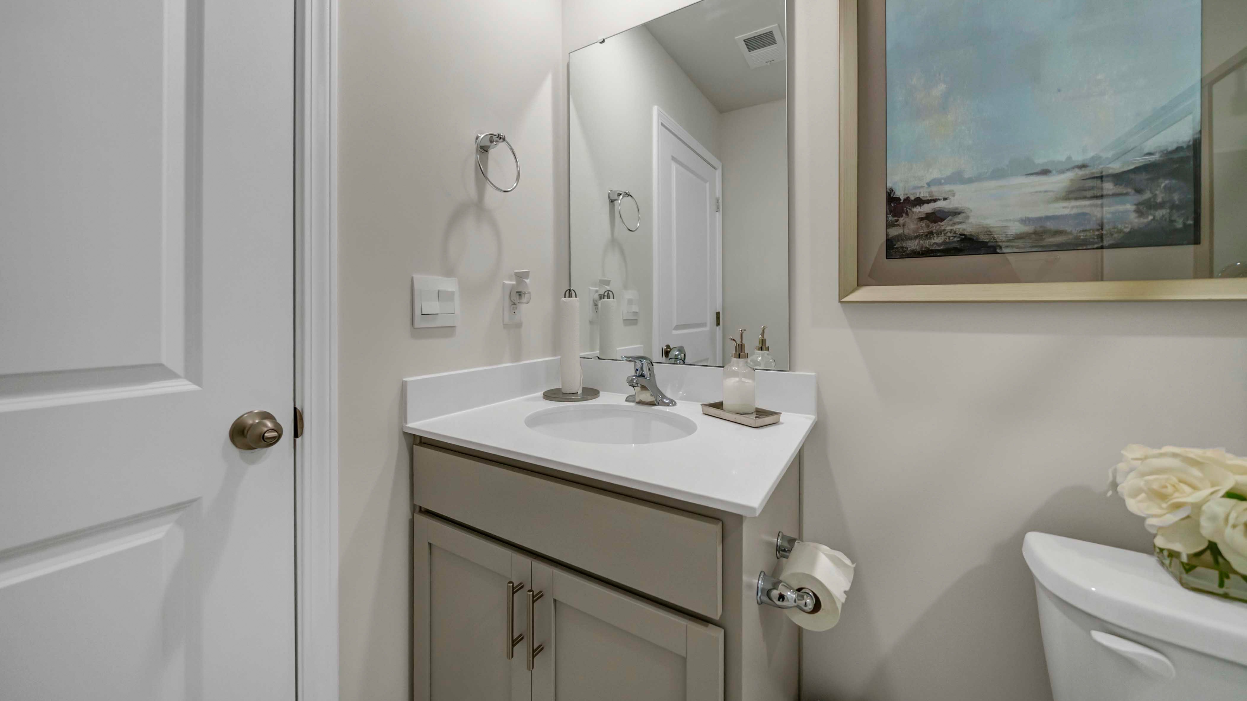 Quartz countertops and gray cabinetry on the bathroom vanities