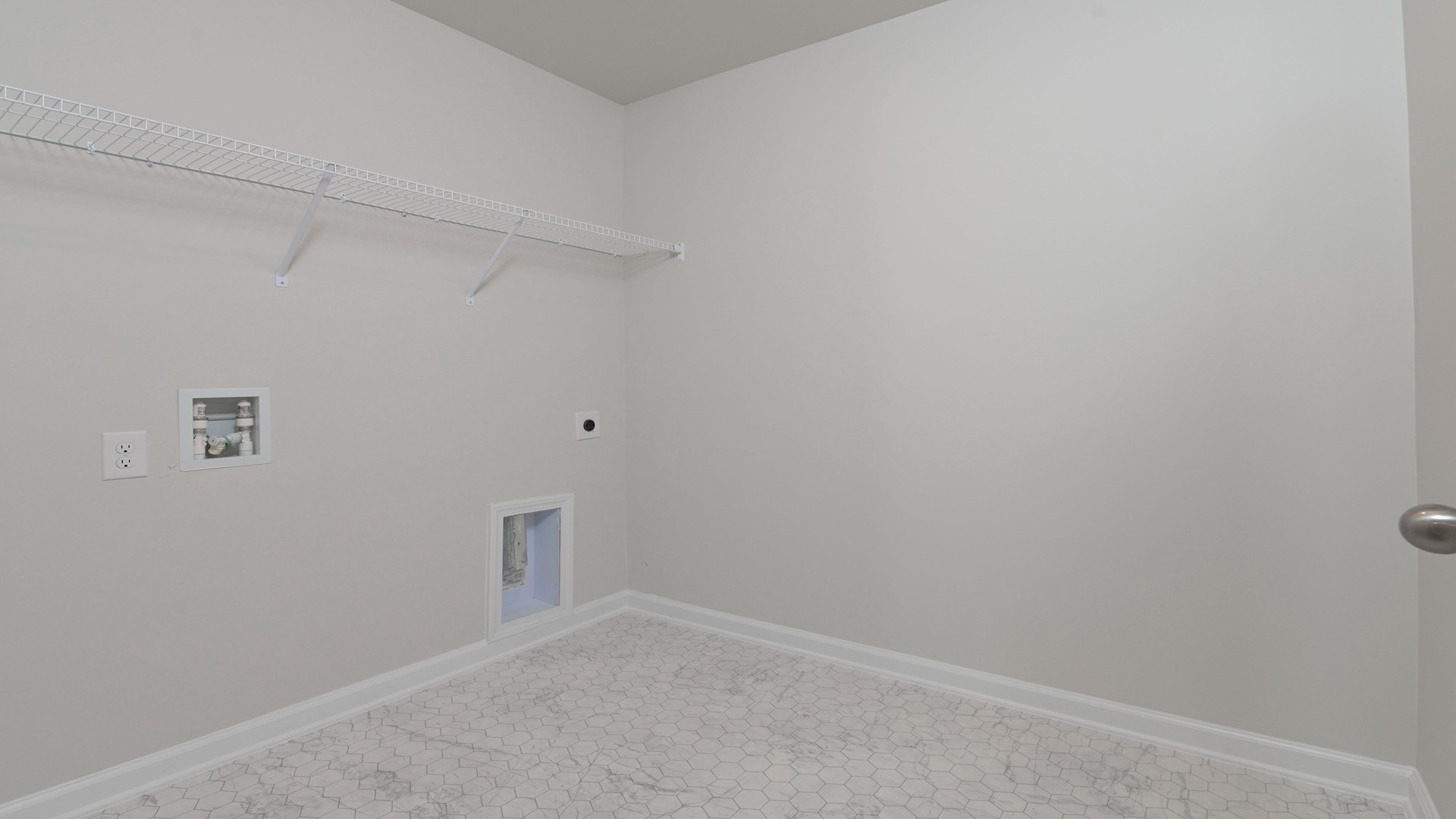 Laundry room upstairs with wire shelving above