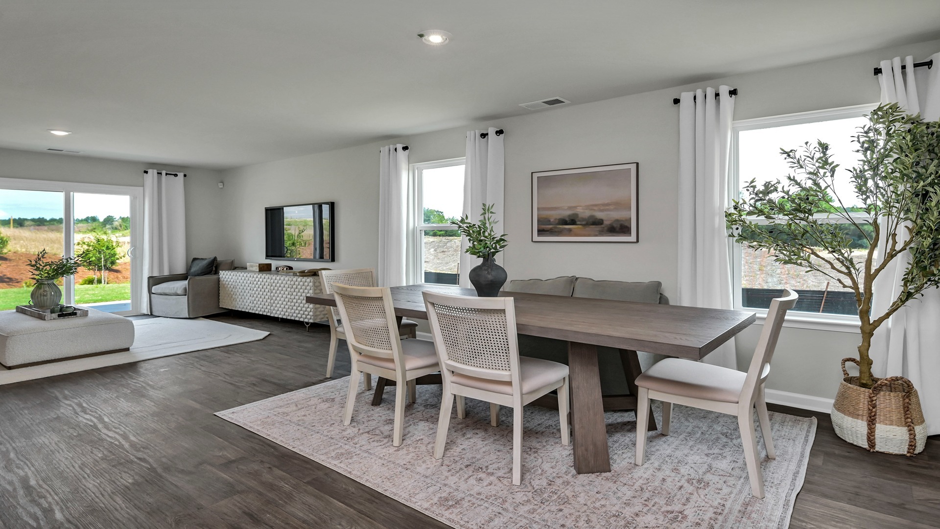 Open dining area with vinyl flooring and windows for natural lighting