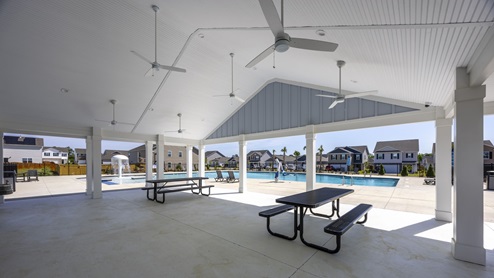 The cabana features a covered area with fans and picnic tables.