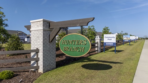 Front entrance sign with brick and wood accent