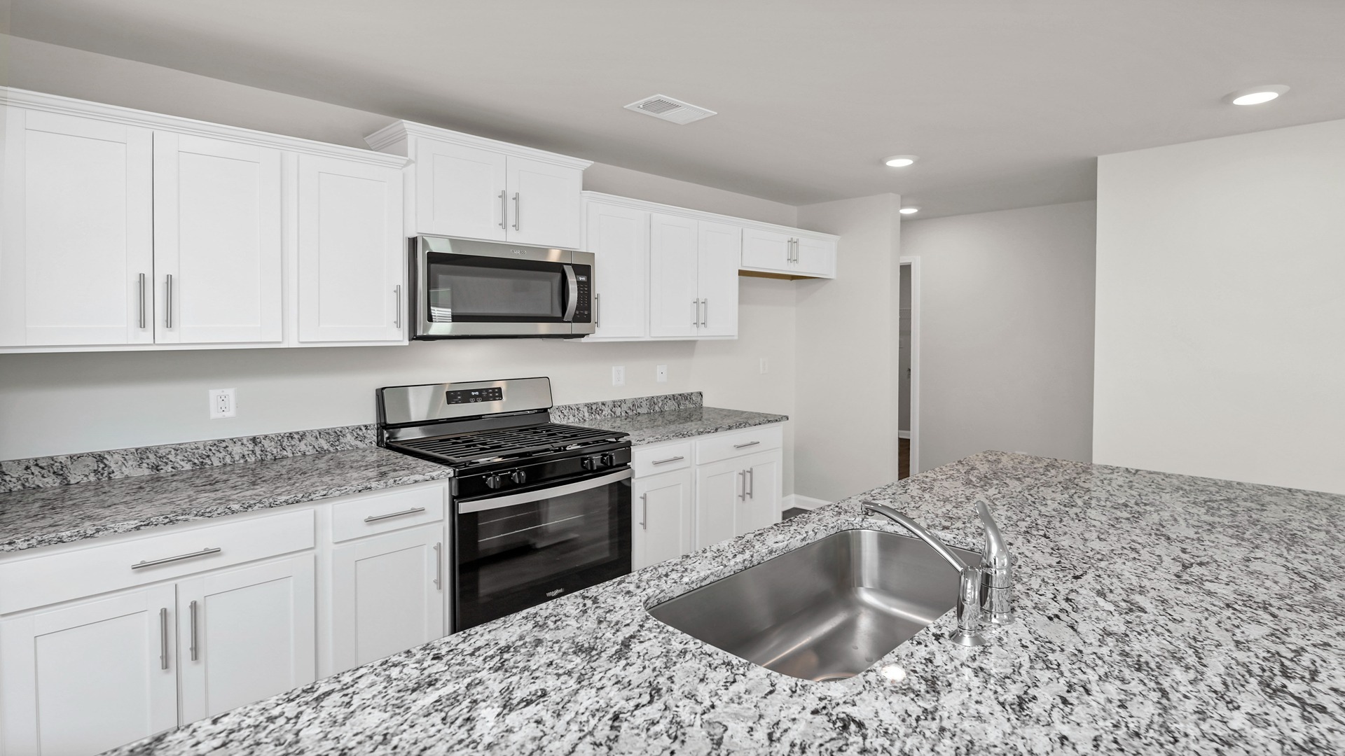 Kitchen with granite countertops and white cabinetry
