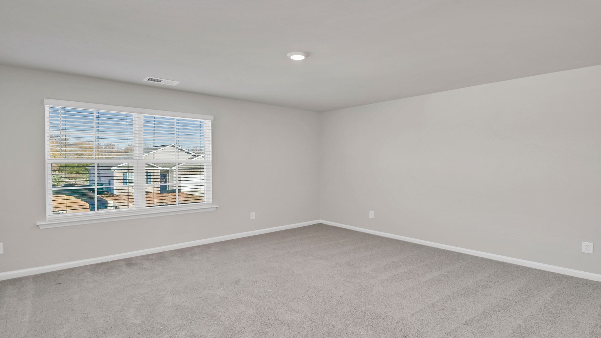 Upstairs living area with large window and carpet flooring