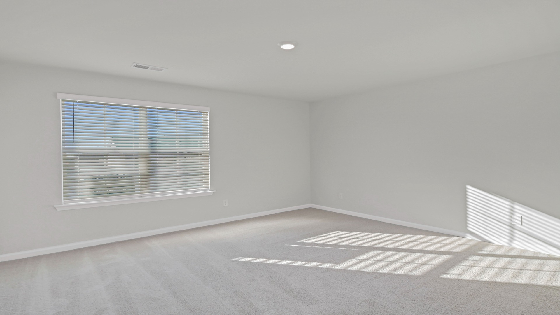 Spacious upstairs living area with large window for light and plush carpet floors
