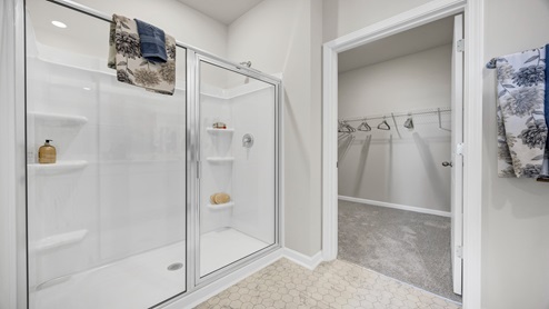 Primary standup shower + entry to primary closet in the bathroom.