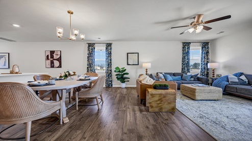 The dining and living area are open concept with ample natural light from large windows.