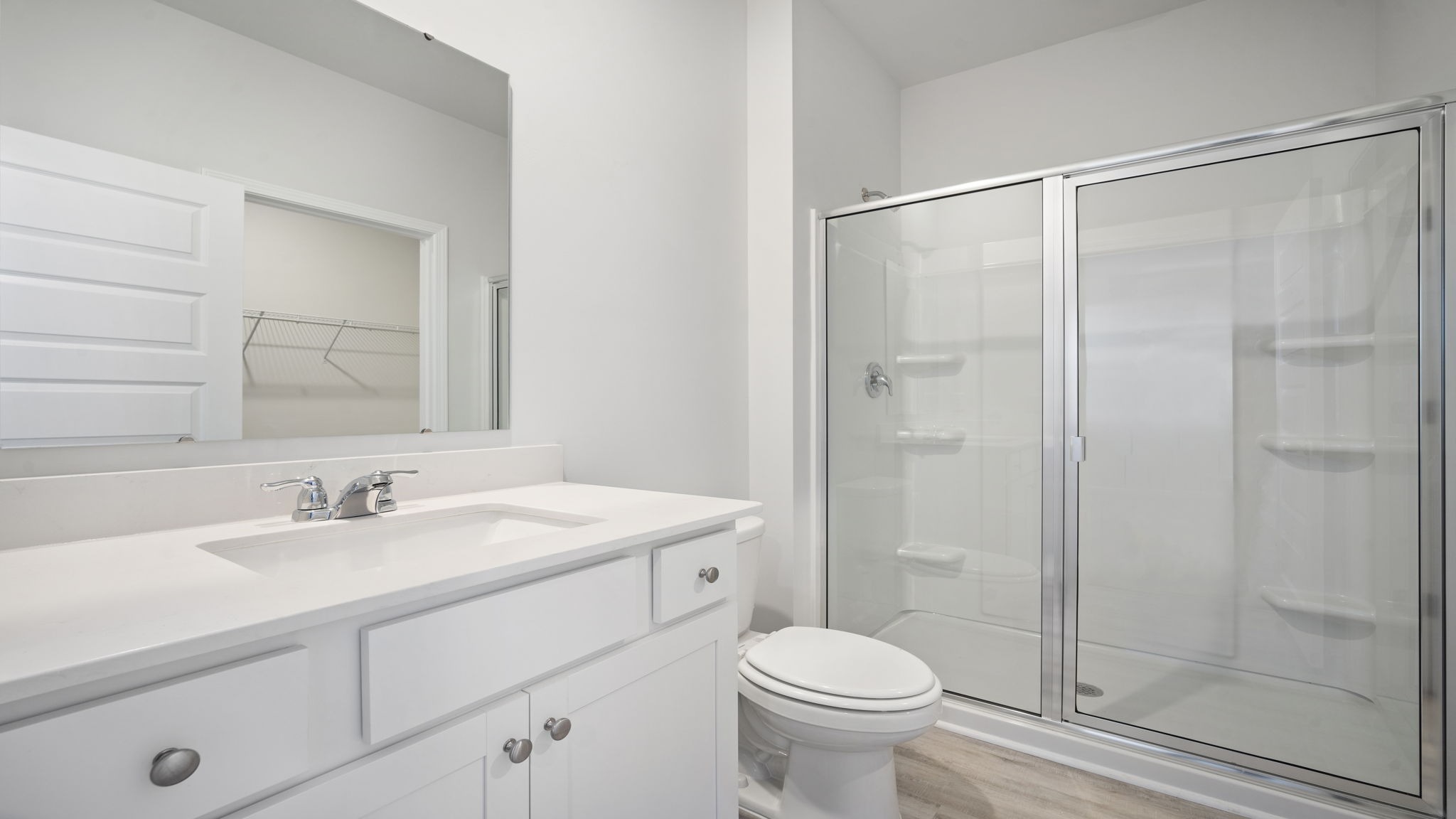 En-suite primary bathroom with walk-in shower with glass doors