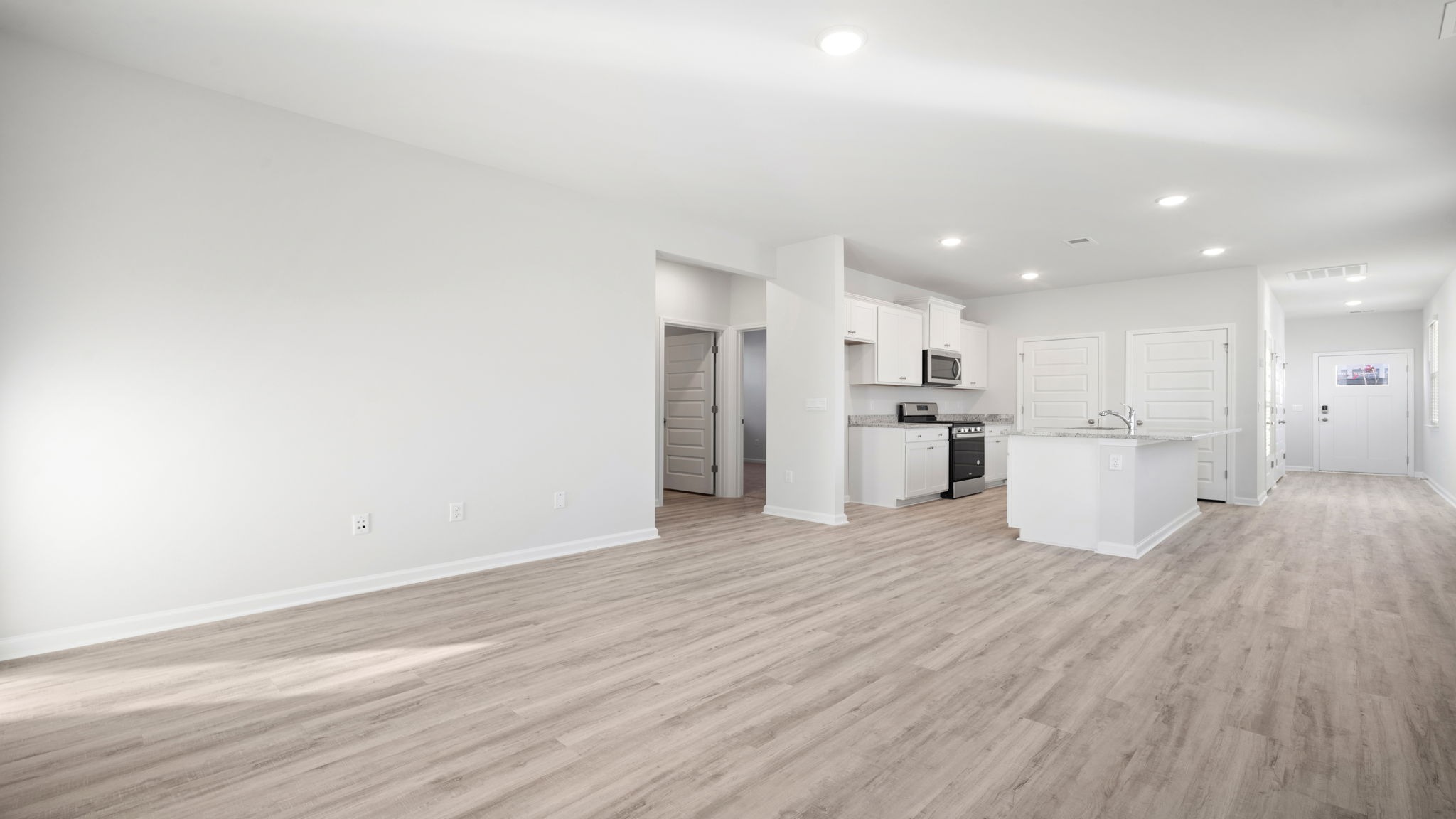 Open concept living and kitchen areas with matching RevWood flooring