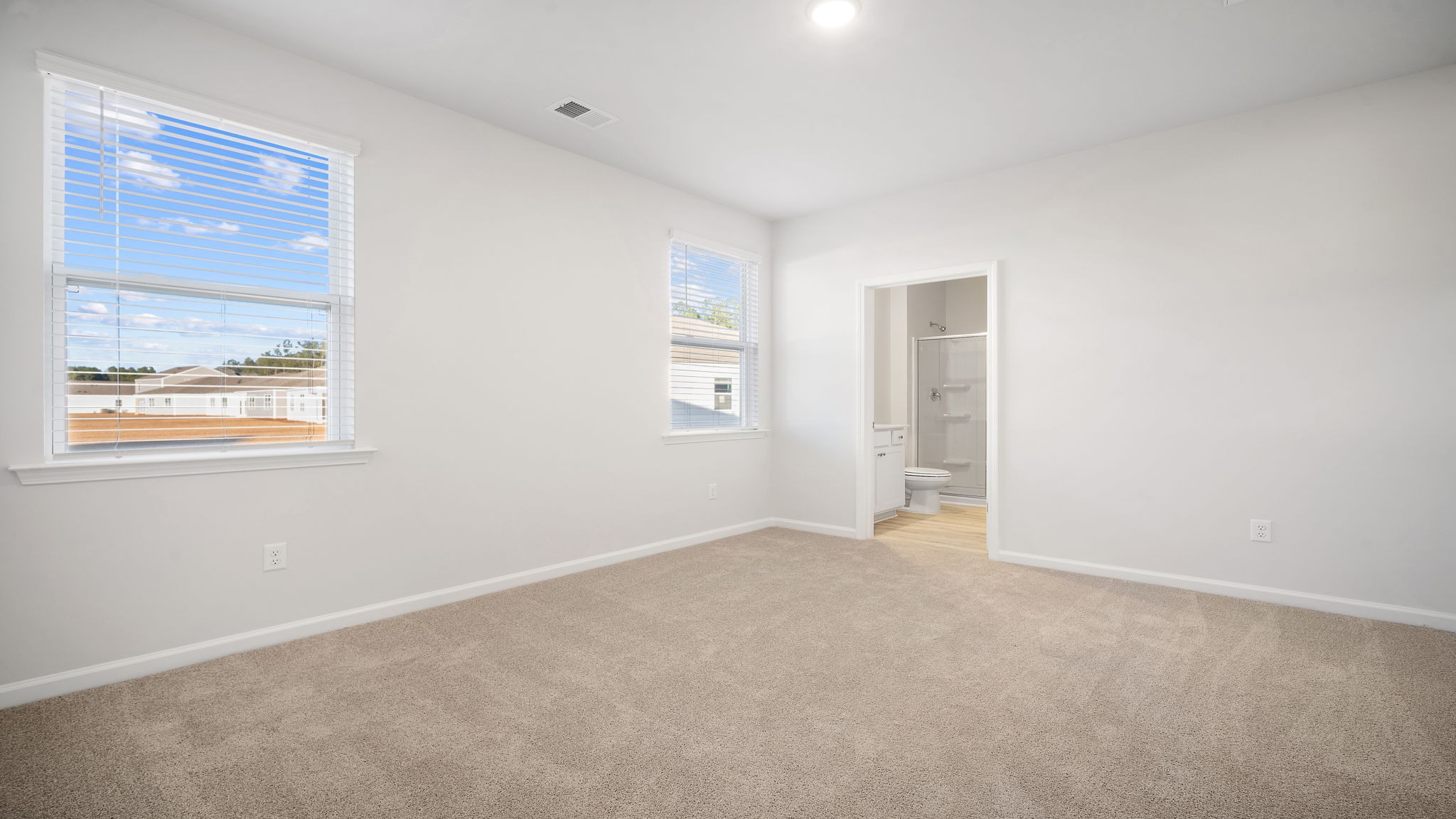 Private primary bedroom tucked into the back of the ranch-style home in Sease's Pond
