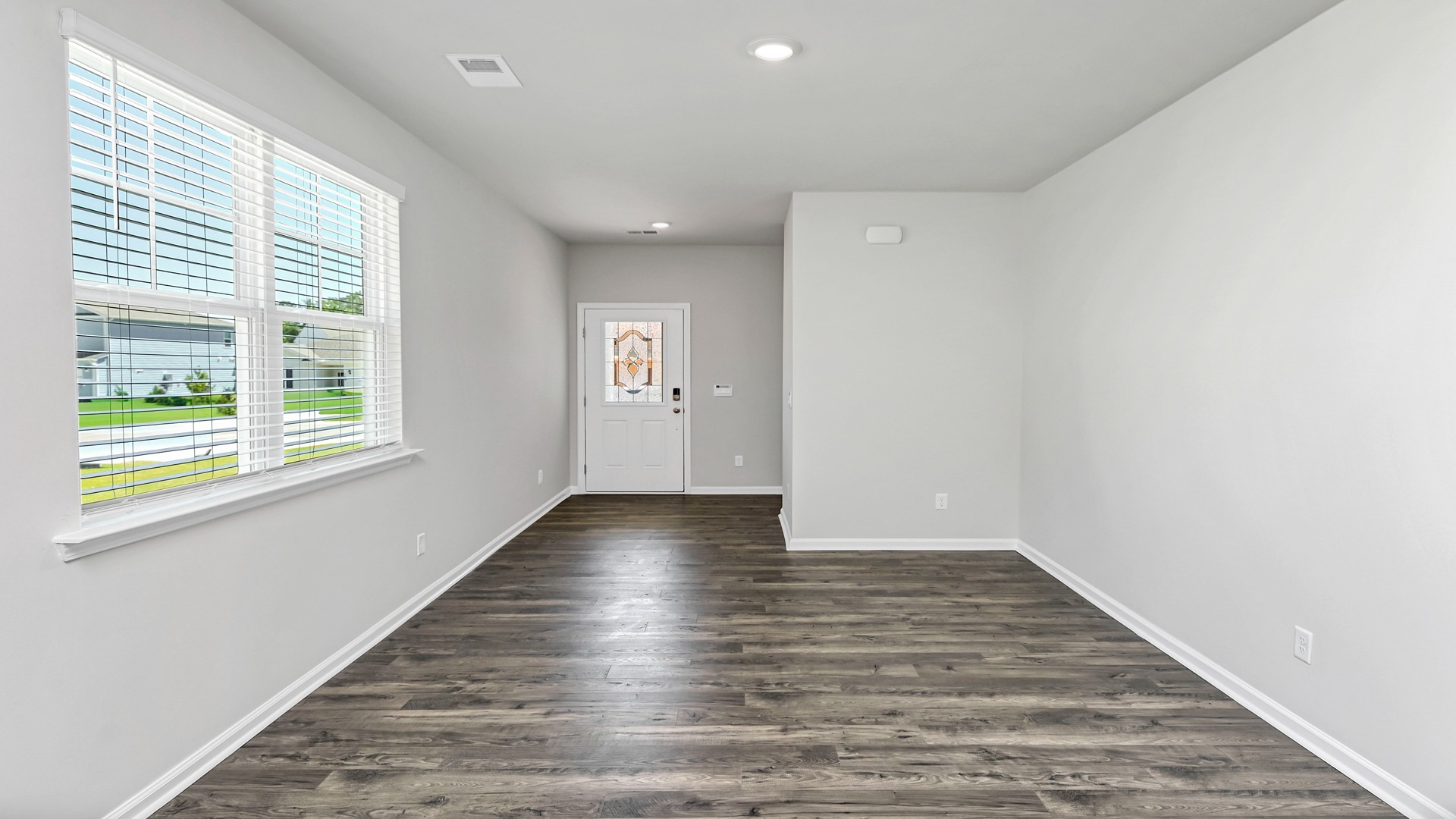 Front entrance and dining area with RevWood flooring and a window for light