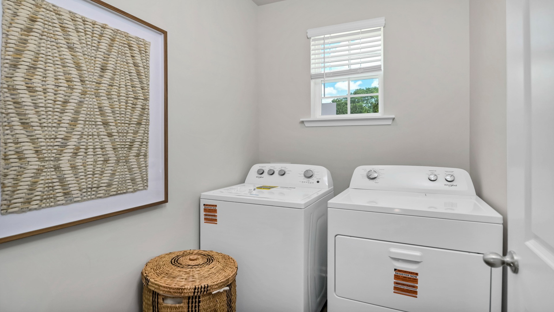 Laundry room at the front of the home with a front facing window and matching washer and dryer