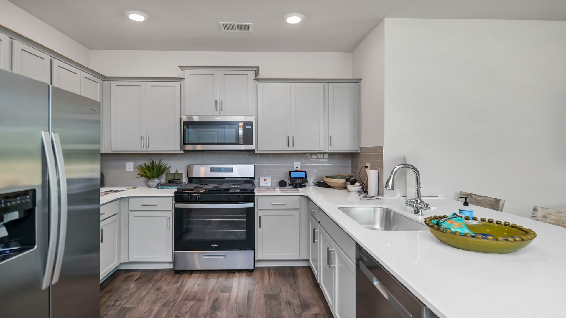 New construction kitchen with gray cabinets and white quartz countertops