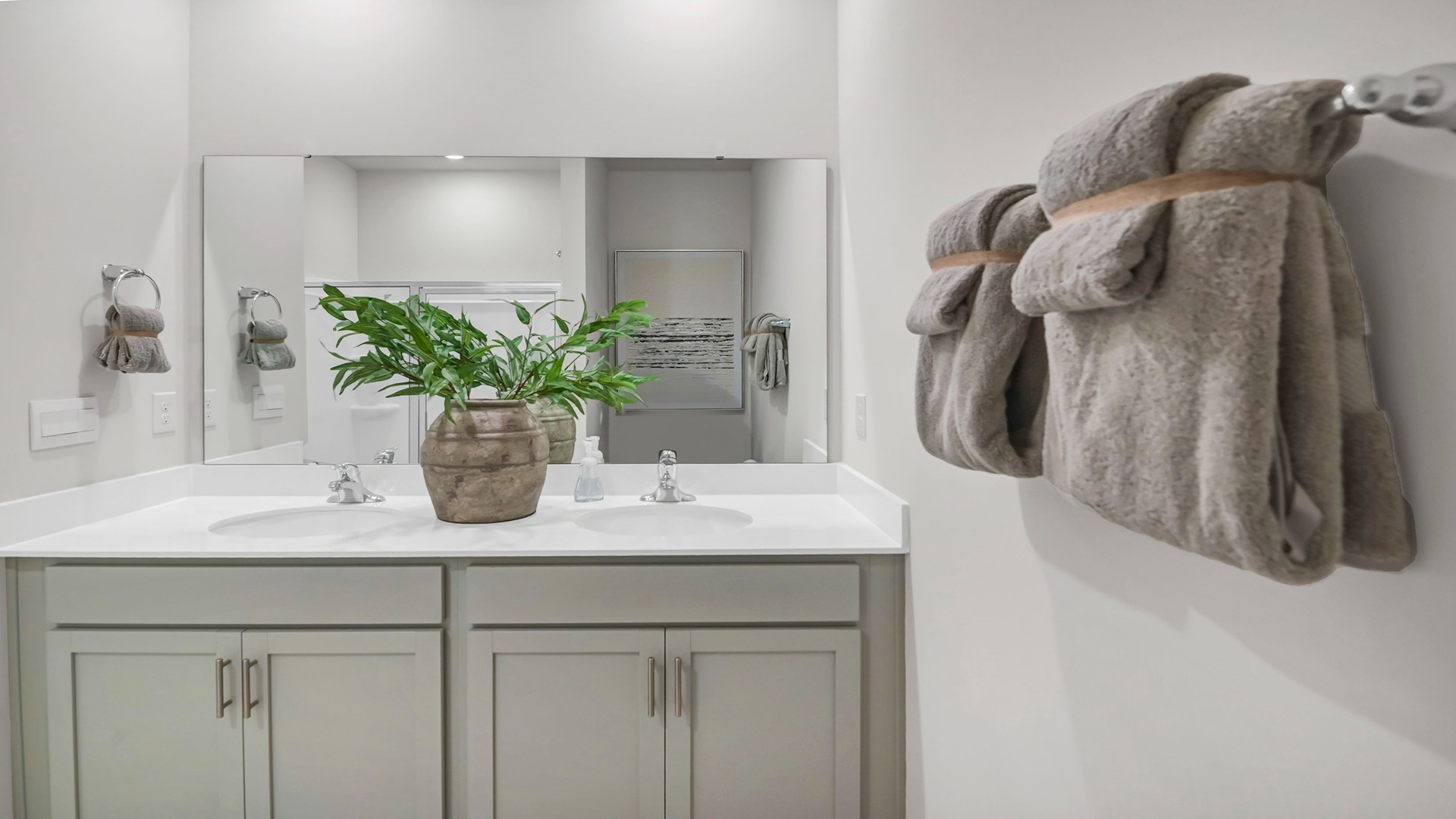 Double primary vanity with quartz countertops and gray cabinetry