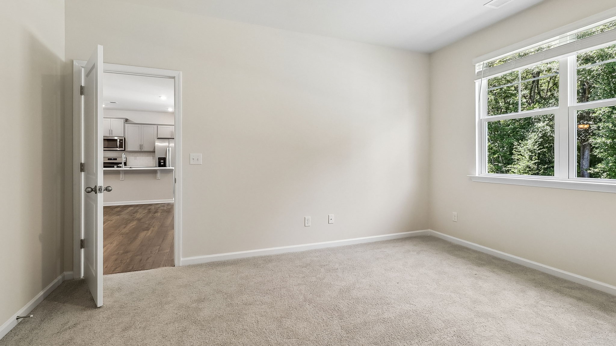 Spacious primary bedroom with large window facing the backyard
