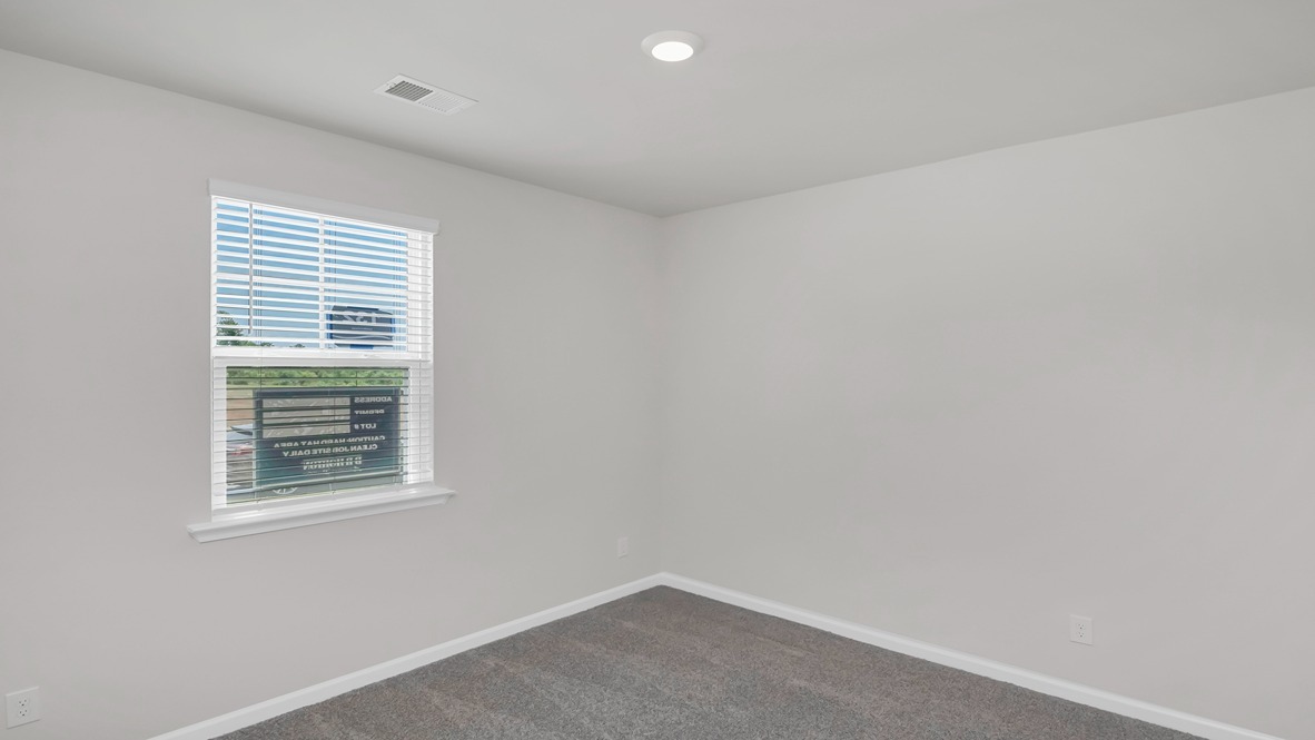 Front bedroom 2 with carpet flooring and a window for light