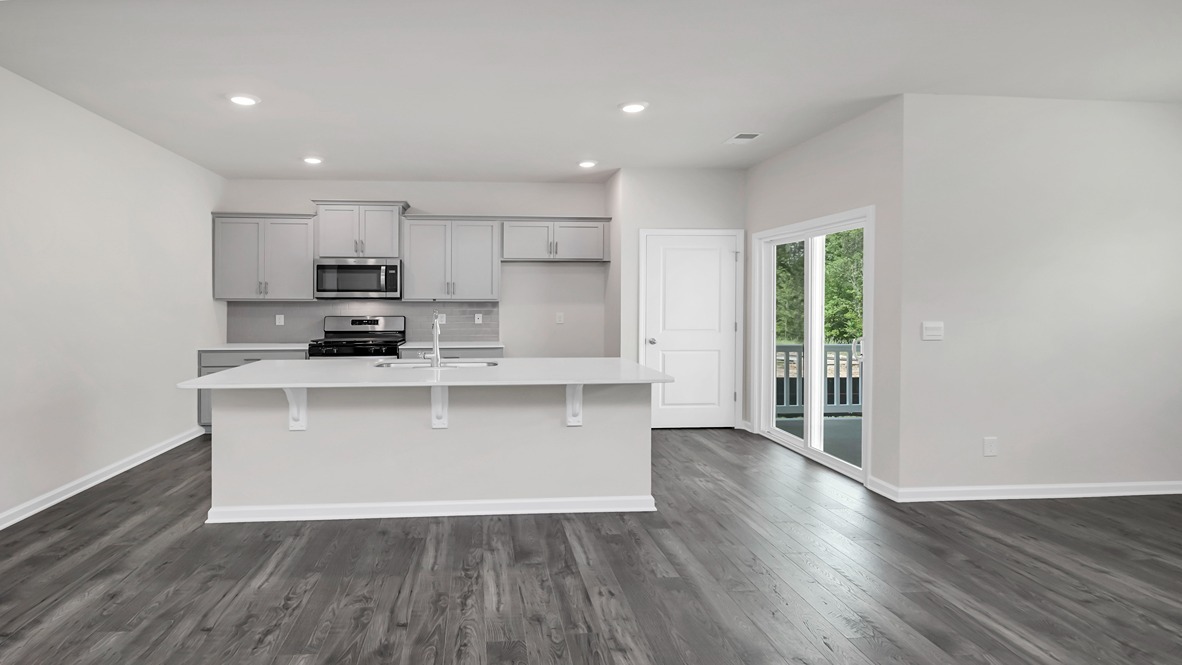 Kitchen space with floating island and access to the back patio through glass sliding doors