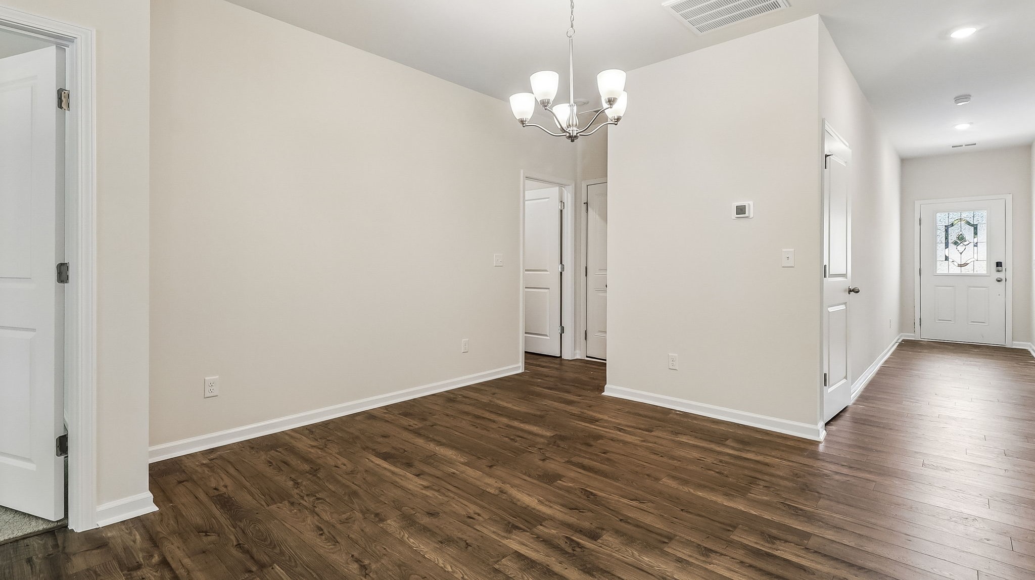 Front foyer of the home extends from the front door with glass insert for natural light