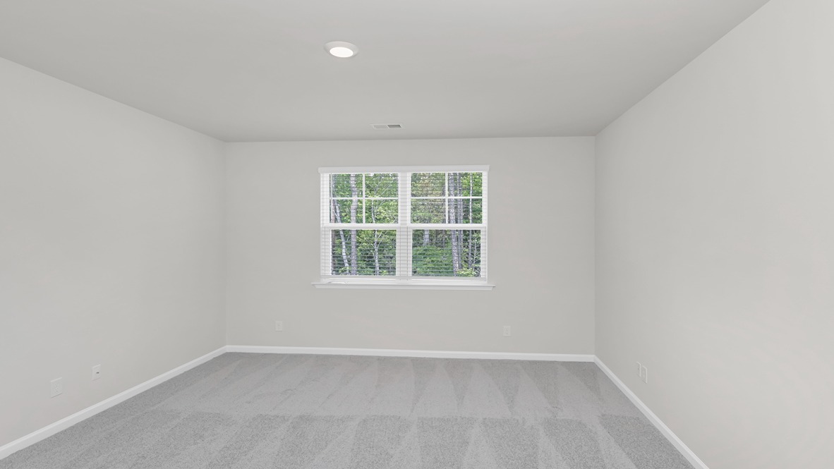 Spacious primary bedroom with large window facing the backyard
