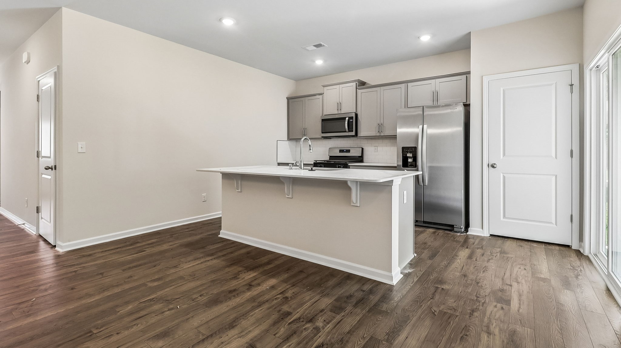 Kitchen space with floating island and access to the back patio through glass sliding doors