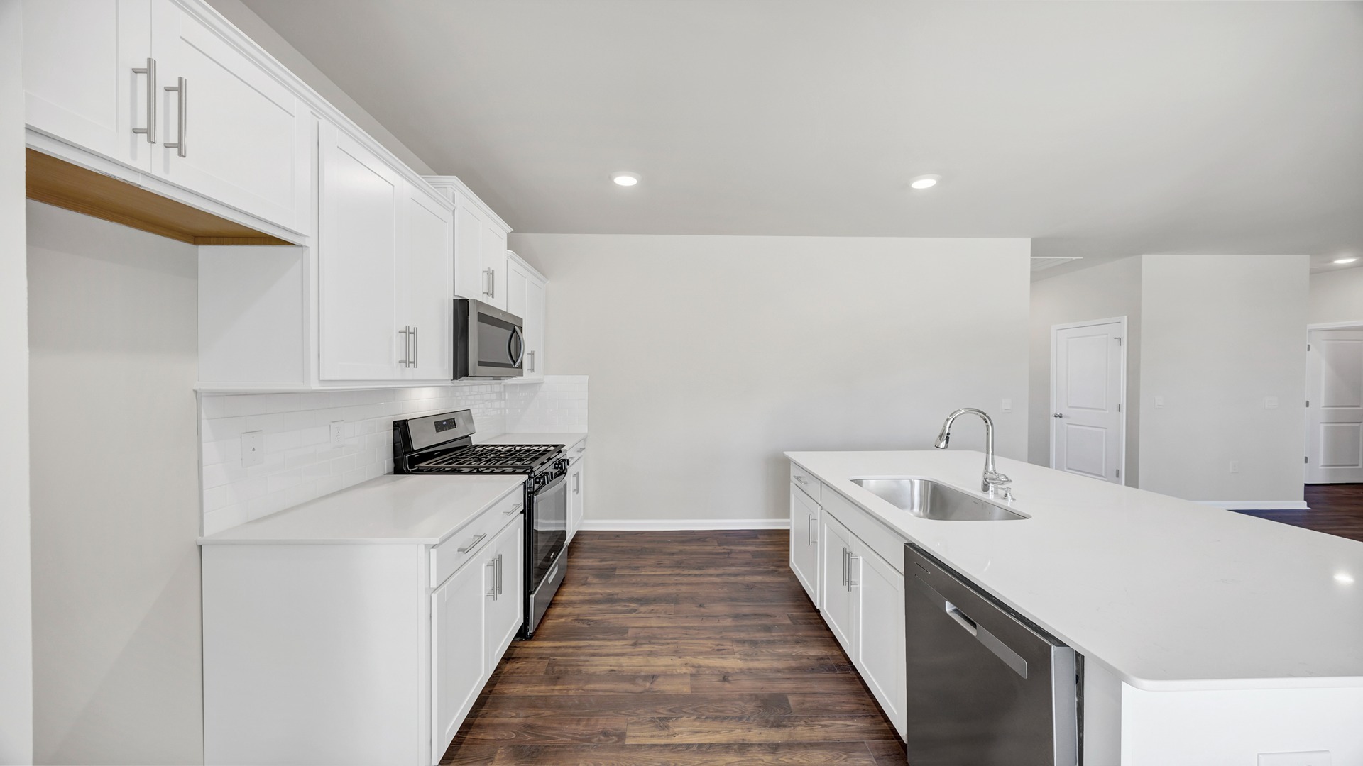 Tile backsplash finishes the modern kitchen space of available home in Sease's Pond