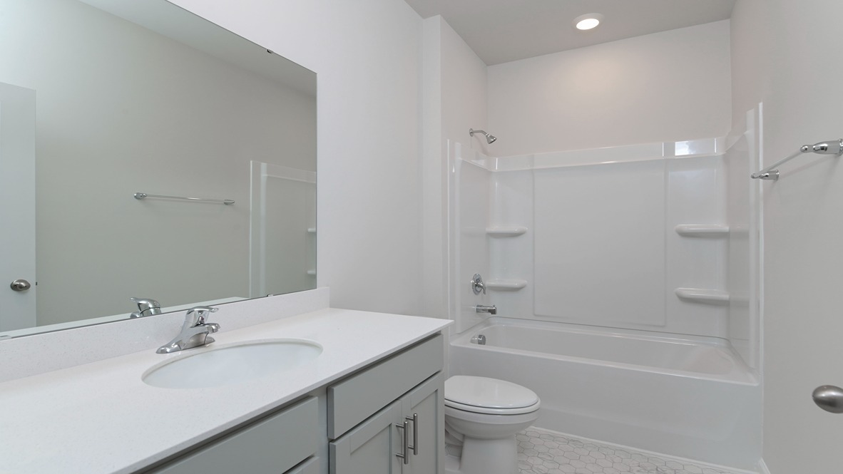 Bathroom 2 is between bedrooms 2 and 3 and features gray cabinetry.