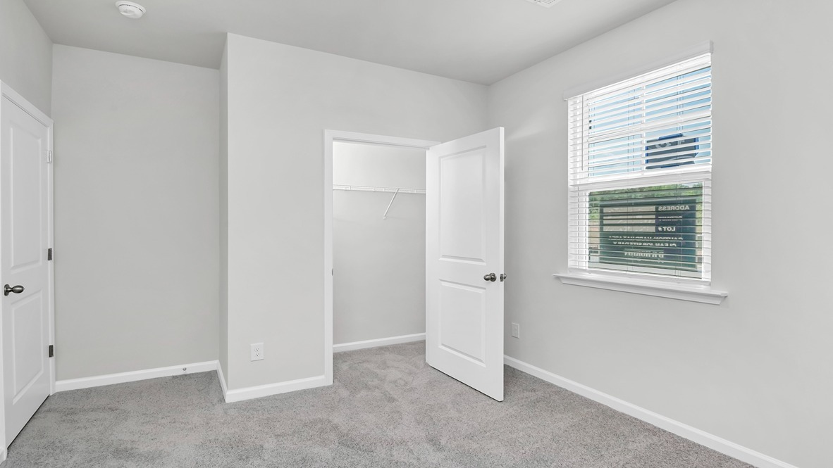 Front bedroom 2 with a window and carpet flooring