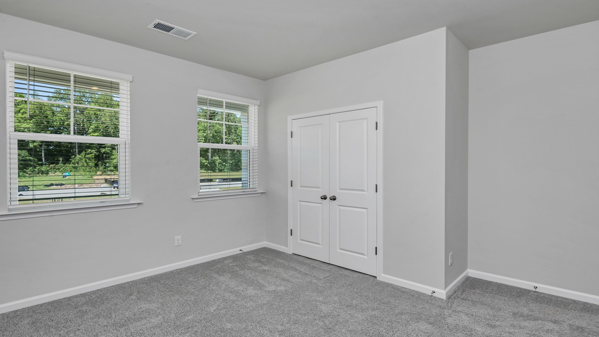 Carpet flooring and 2 windows in Bedroom 2 in the Allex floorplan