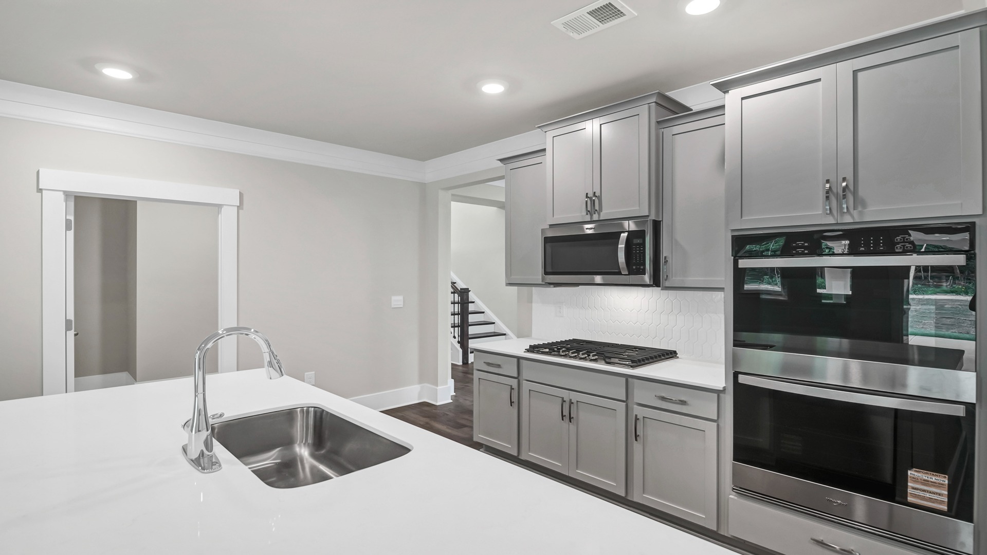 White quartz countertops finish the kitchen space