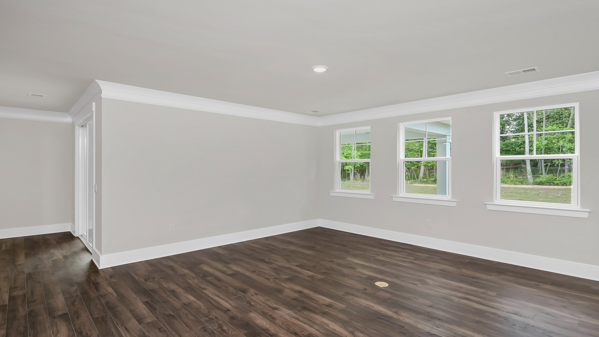 Living area with several windows and Revwood flooring