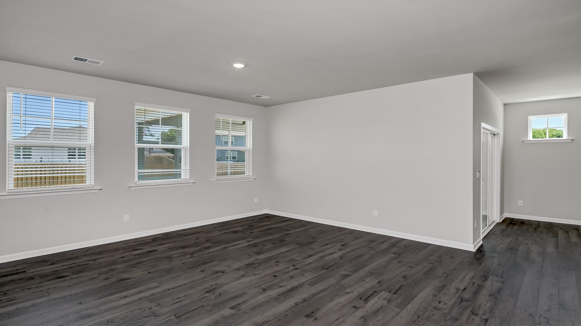 Open living area in home for sale with several windows for light