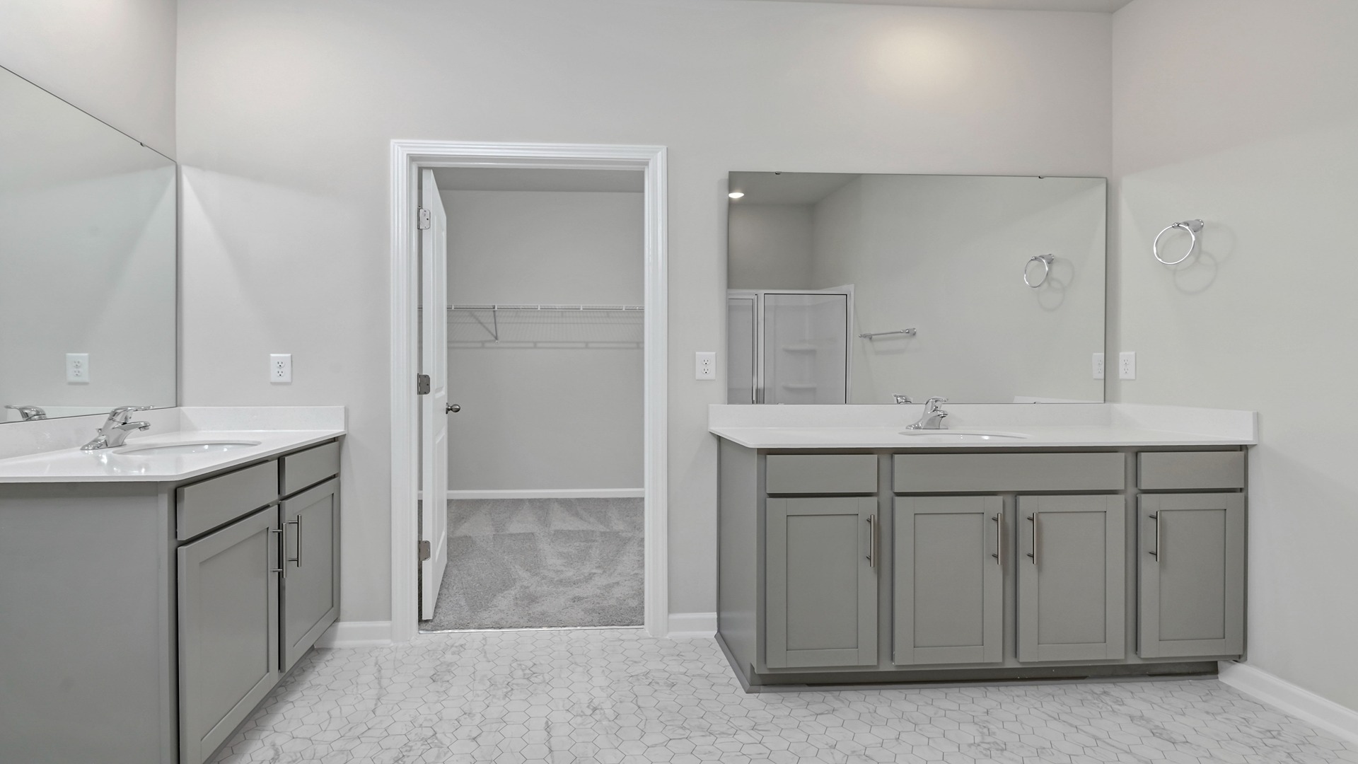 En-suite primary bathroom with 2 vanities and gray cabinetry