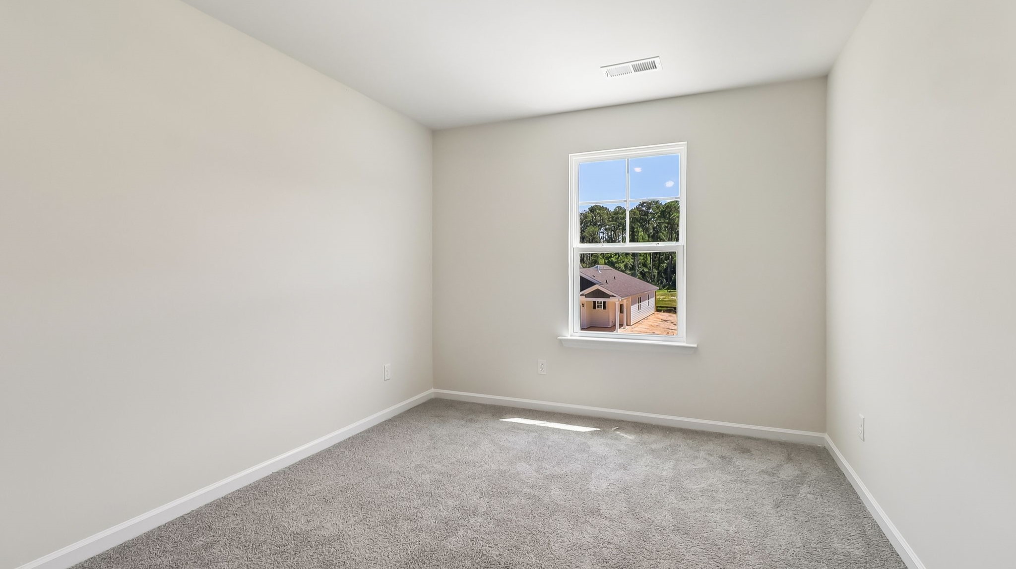 Bedroom 2 upstairs with a window for light and carpet floors