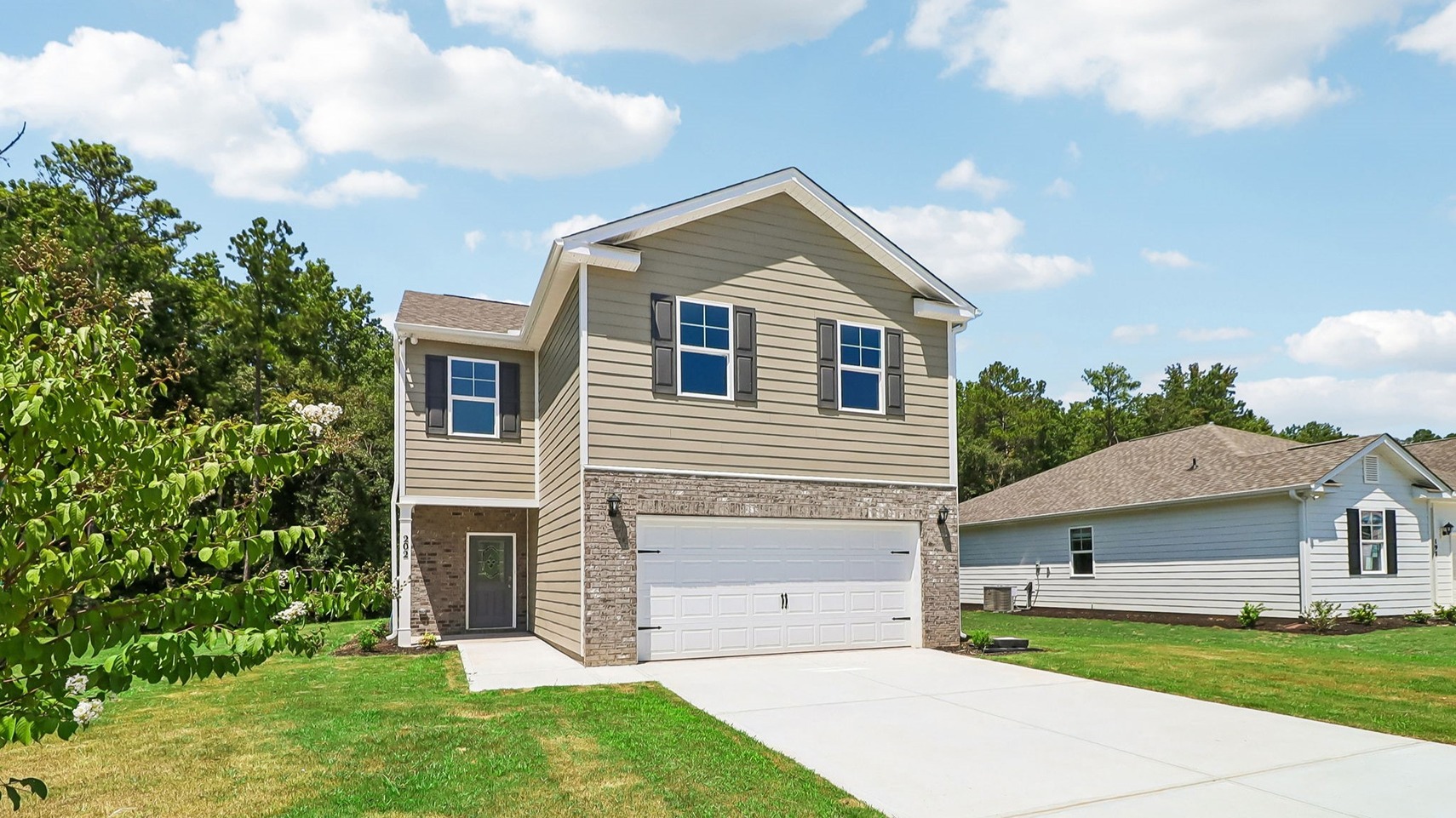 Partial brick siding and a 2-car garage featured on new construction home for sale in Sease's Pond