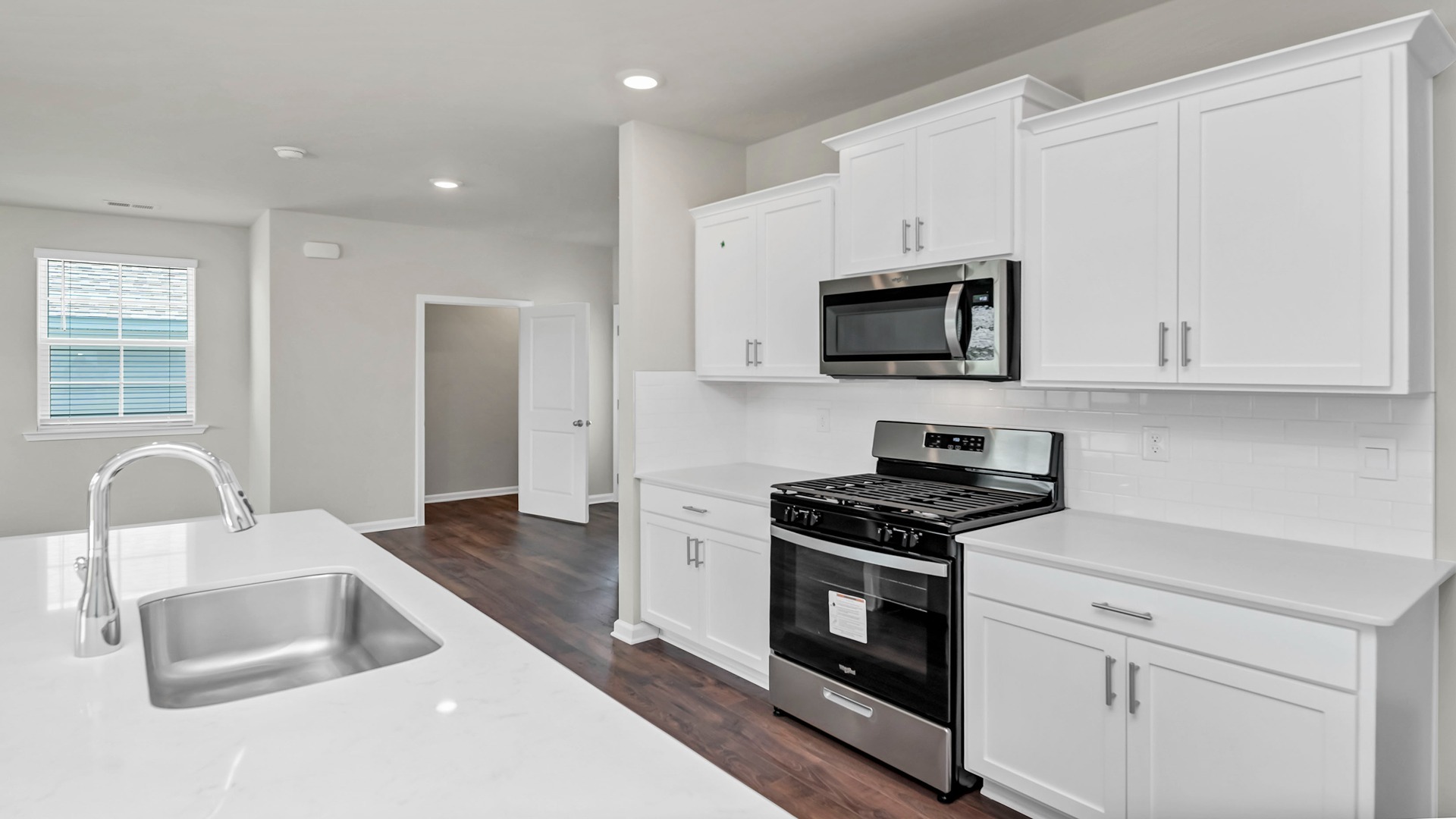 White quartz countertops and tile backsplash finish the kitchen