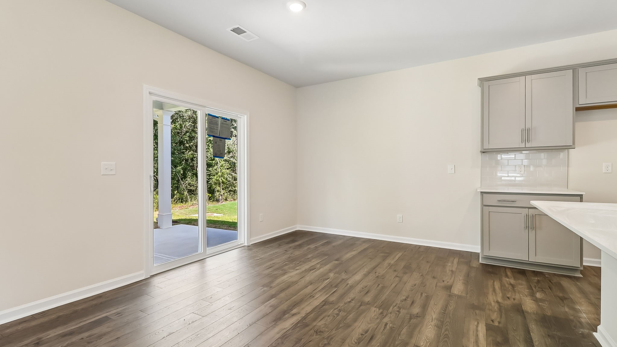 Dining area with vinyl floors and glass sliding doors that lead to the back patio