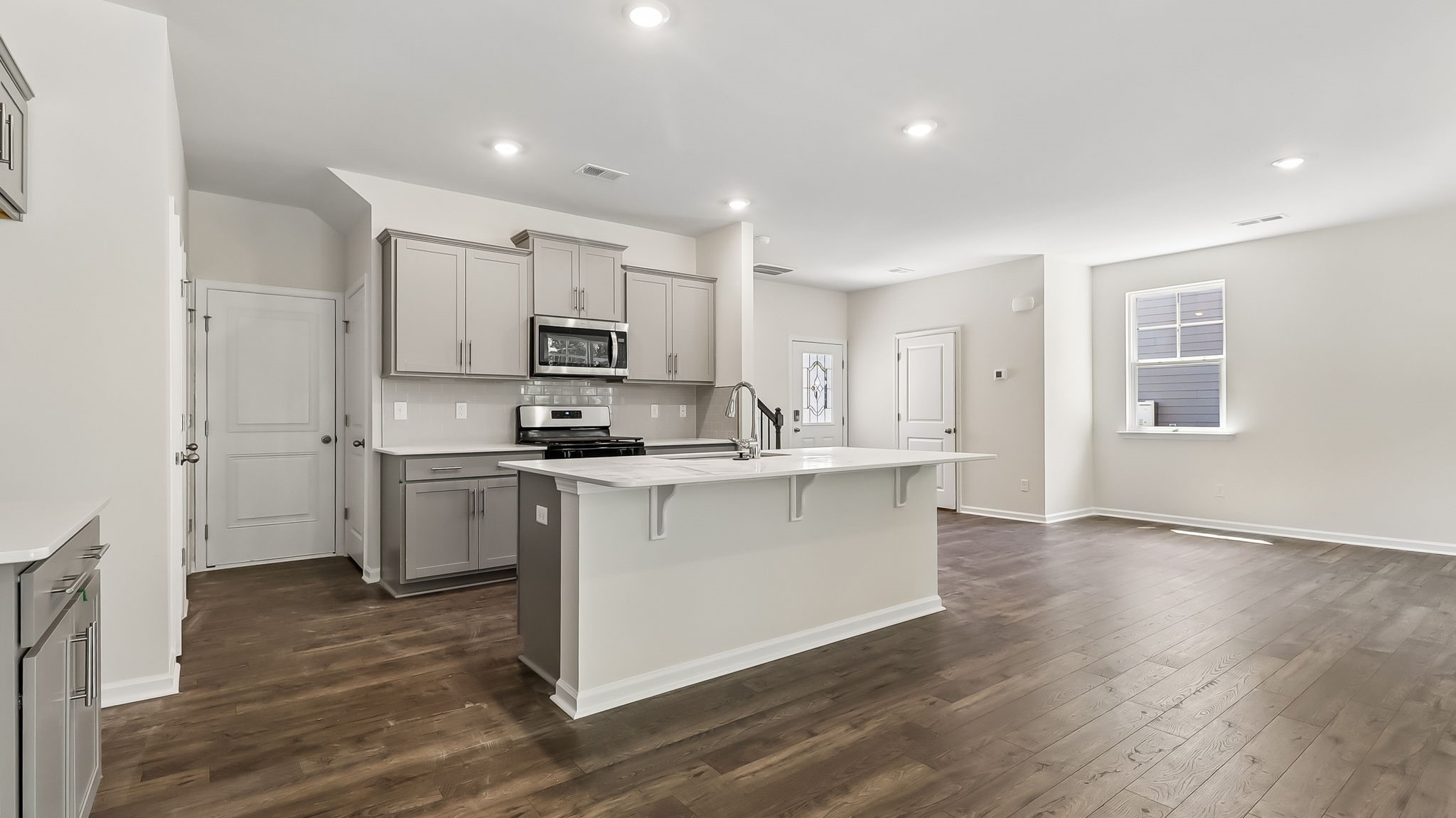 Aisle kitchen in Sease's Pond with quartz countertops and gray shaker-style cabinetry.