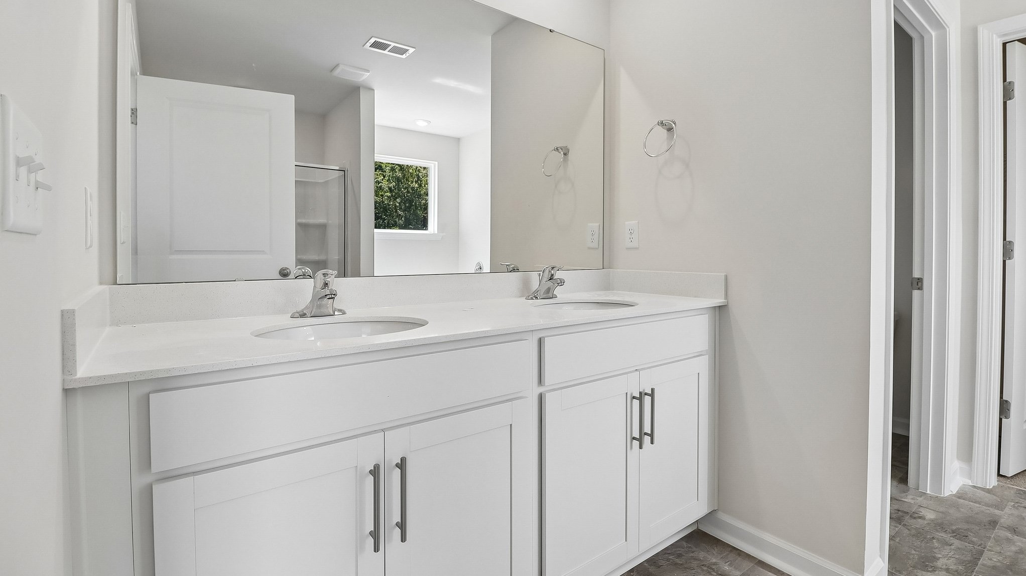 Double primary bathroom vanity with quartz countertops and white cabinets