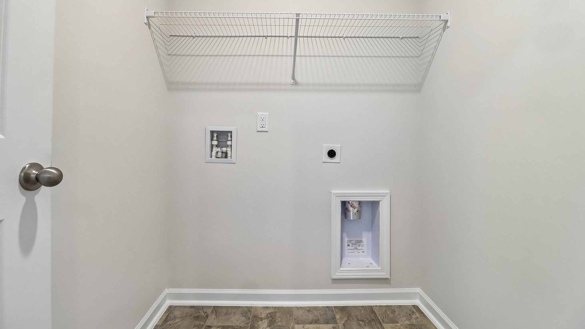 Laundry room upstairs with wire shelving above