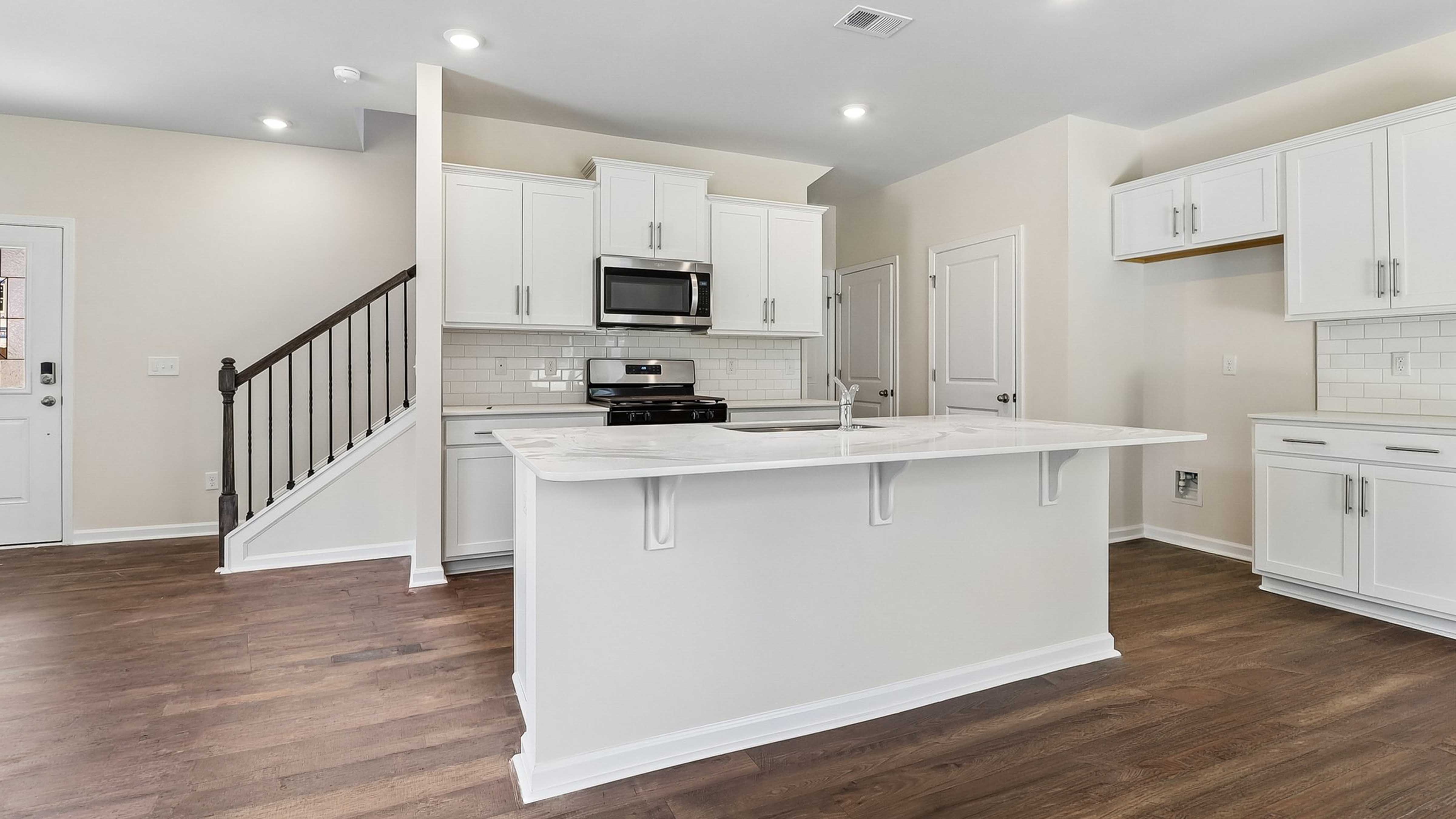 Modern kitchen space with quartz countertops and a floating island in home for sale in Sease's Podn