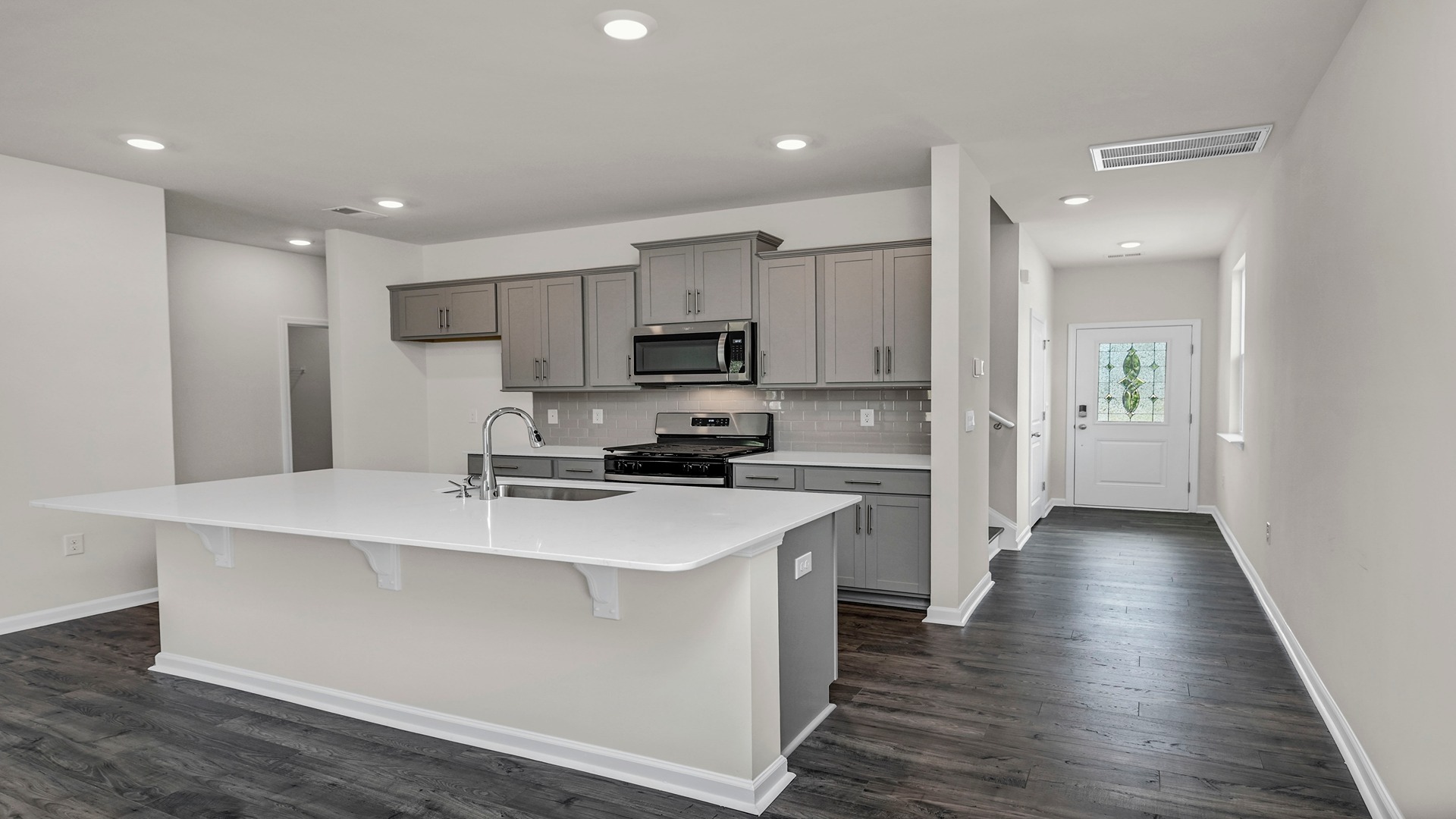 Front foyer of new construction home leads to the modern kitchen area