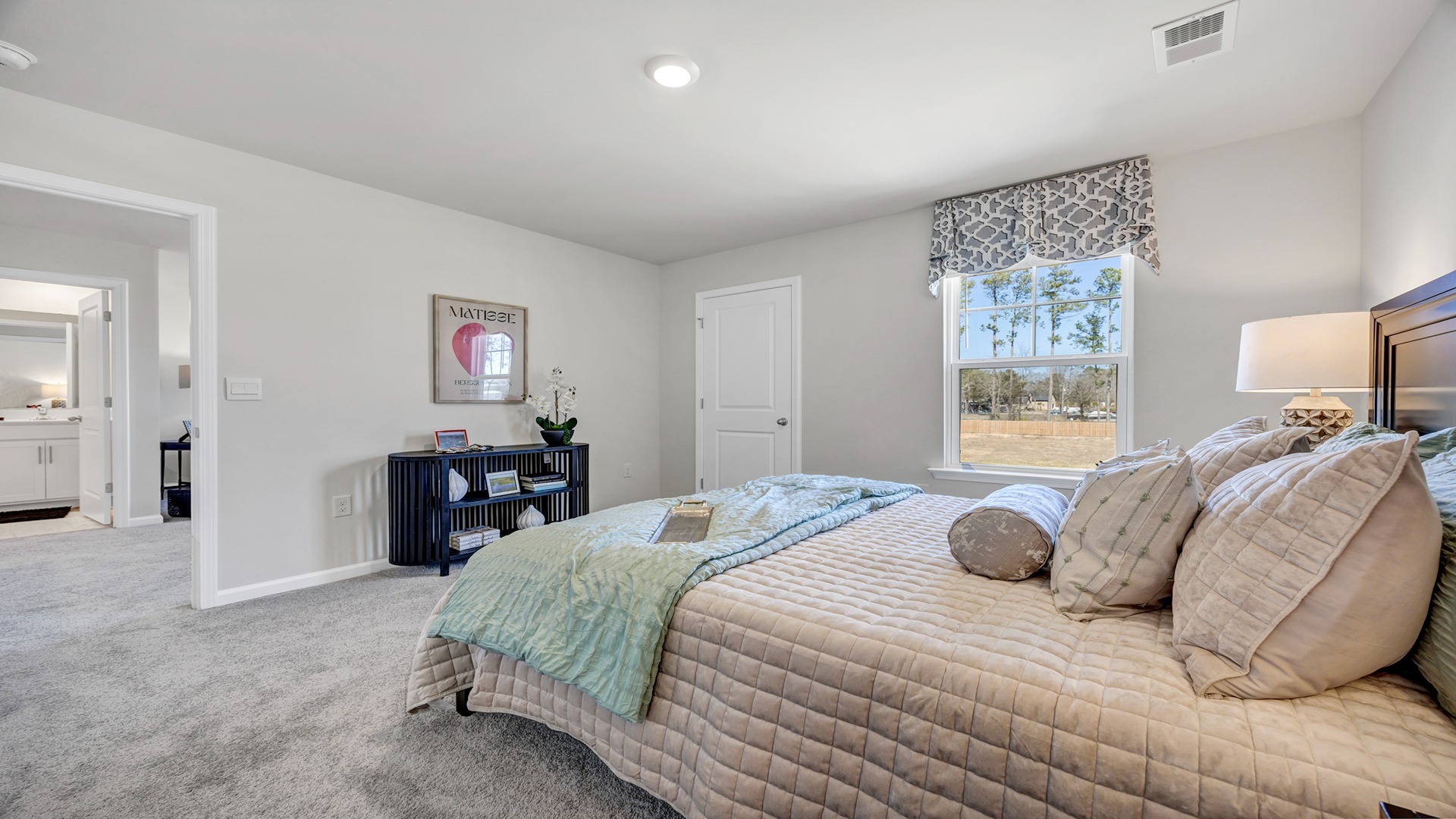 Window for light and plush carpet flooring in bedroom 4 of the Manning