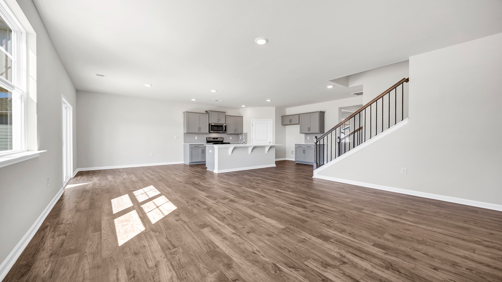 Open concept dining, kitchen, and living areas with RevWood floors