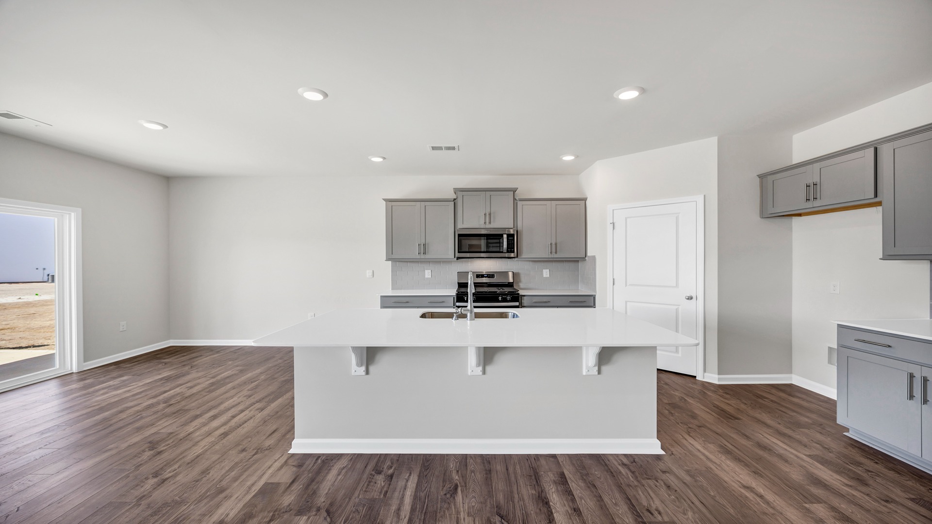 Hayden kitchen with sleek white quartz countertops, gray cabinetry, and tile backsplash